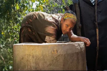 Selamawit stirs cow dung after adding it to the biogas digester. As it breaks down, it produces gas they now use for cooking instead of firewood. Photo: World Bank / Ci-Dev